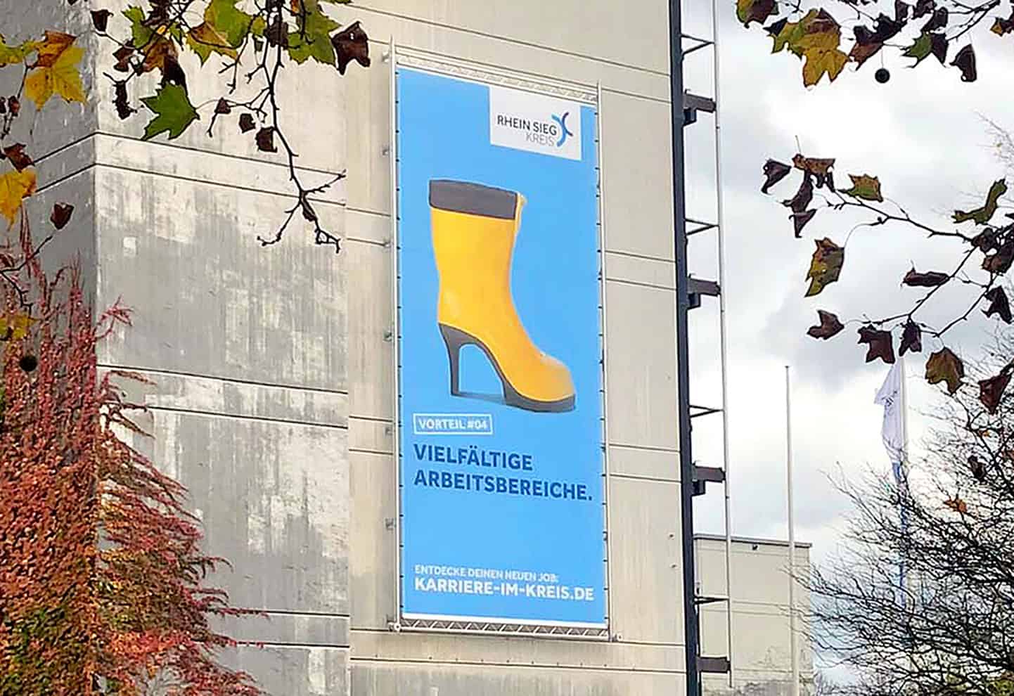 Karrierebanner des Rhein-Sieg-Kreises mit gelbem Gummistiefel und dem Slogan „Vielfältige Arbeitsbereiche“.