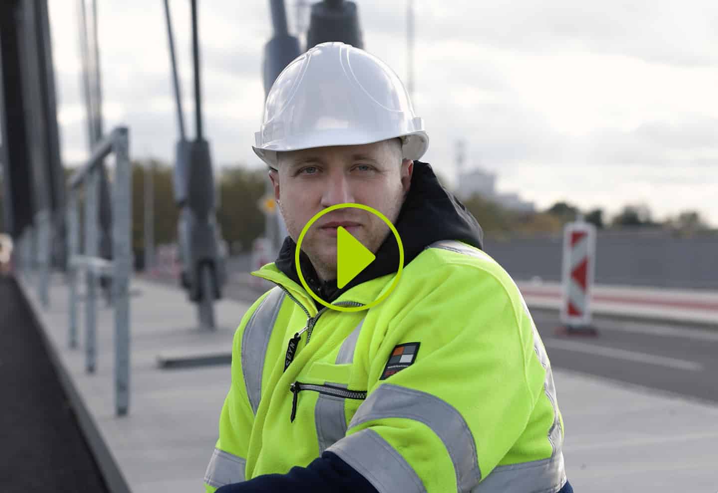 Mitarbeiter auf einer Baustelle mit Schutzhelm und Warnjacke als Vorschaubild für ein Recruiting-Video.