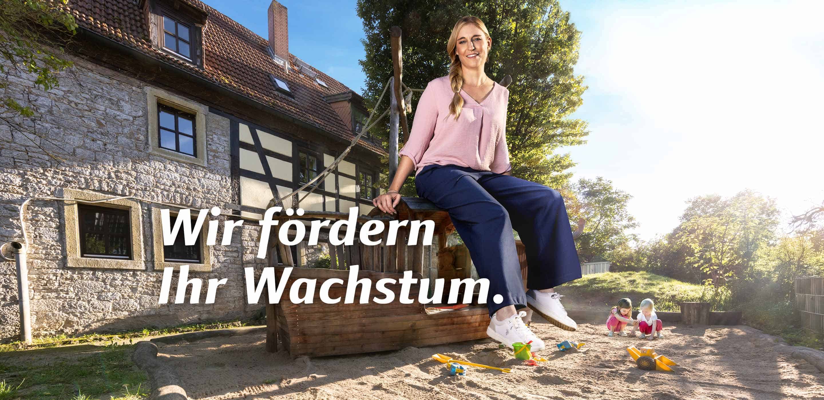 Mitarbeiterin der Stadt Würzburg auf einem Spielplatz mit dem Motiv „Wir fördern Ihr Wachstum“.
